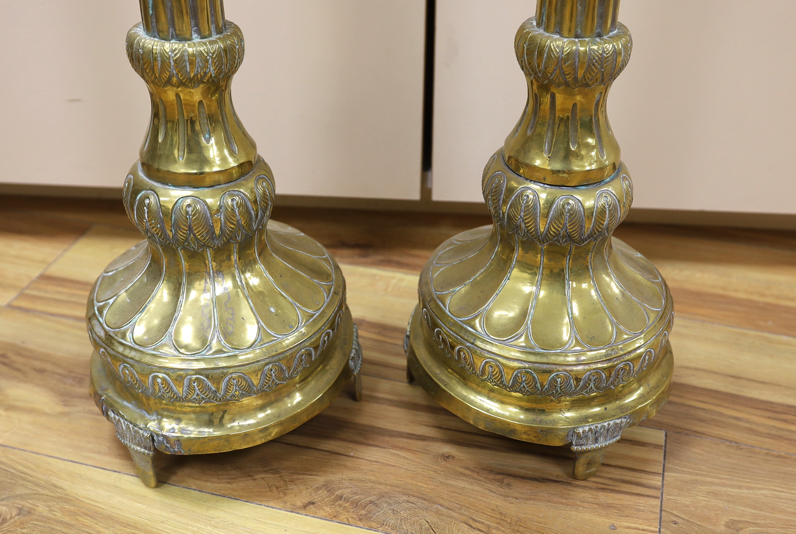 A pair of tall 19th century repoussé brass pricket altar sticks, 76cm high